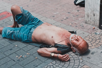 赤裸上身躺在砖砌路面上的男子